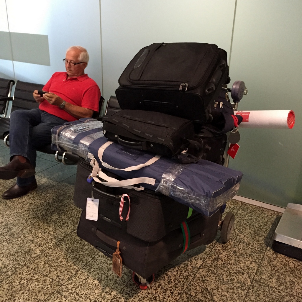 A big pile of luggage at the airport, ready for check-in.
