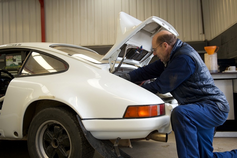Francis Tuthill working on a white Porsche.